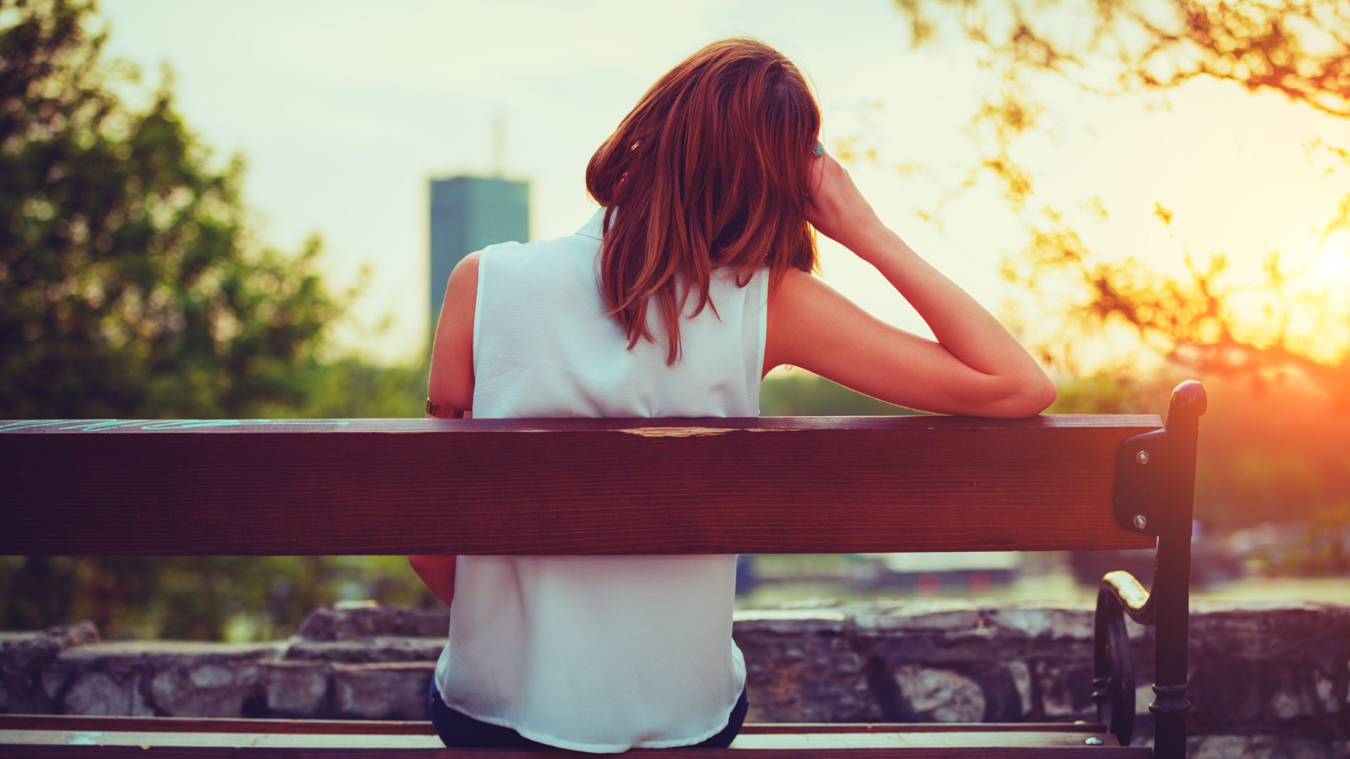 Girl enjoying city view from a bench.