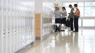 School children by lockers in corridor