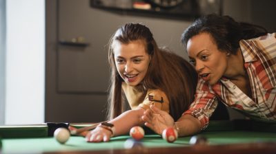 Two young people playing pool in a pub