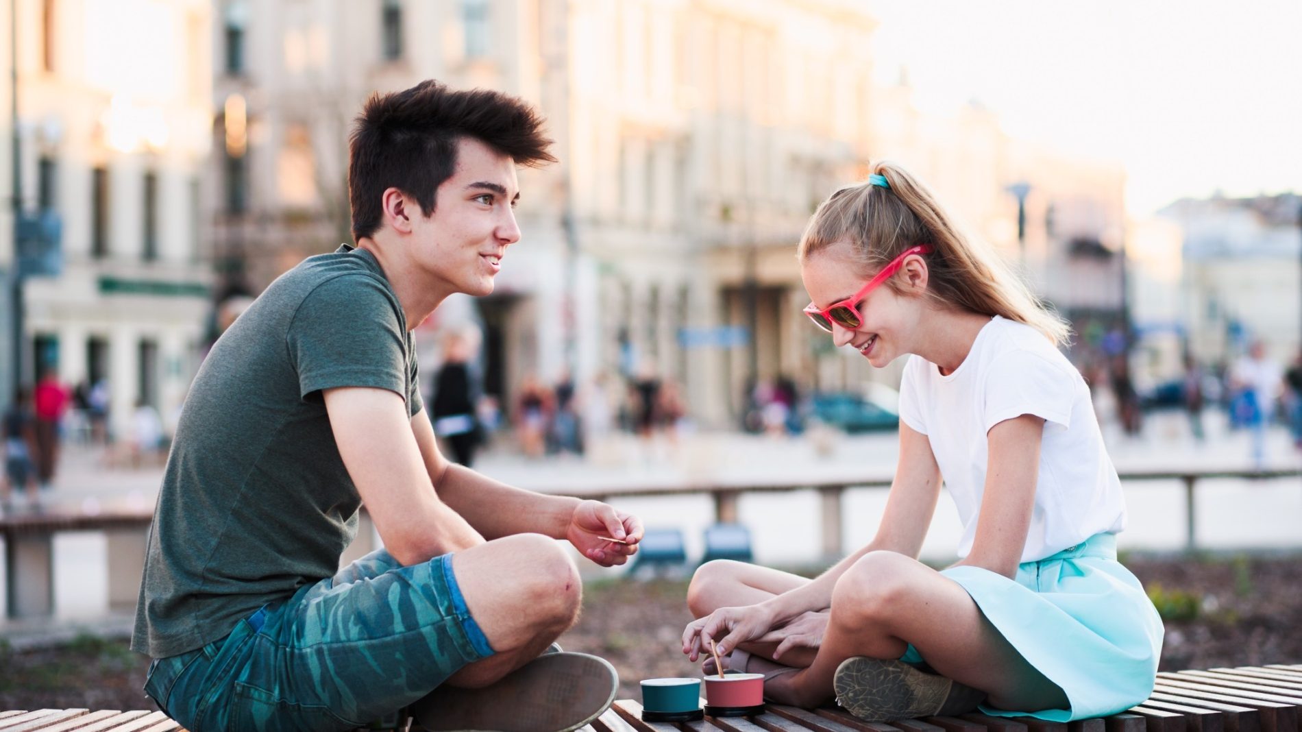 Two-young-people-sitting-on-a-bridge-together