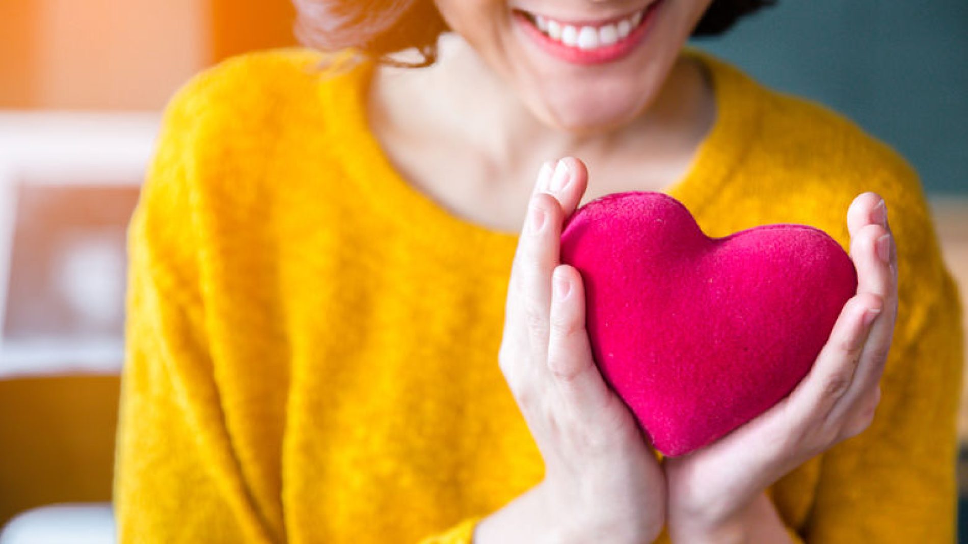 Woman-smiling-and-holding-toy-heart