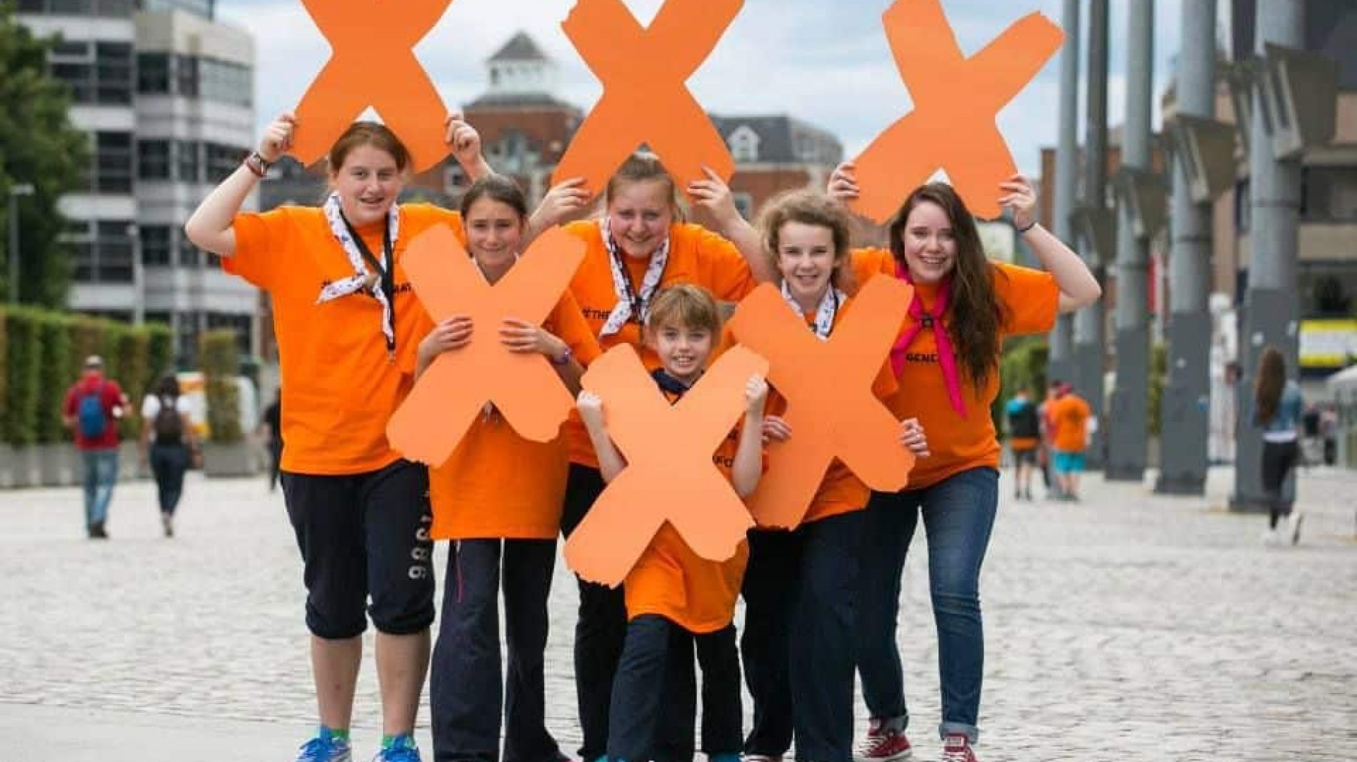 group of young people holding up x's