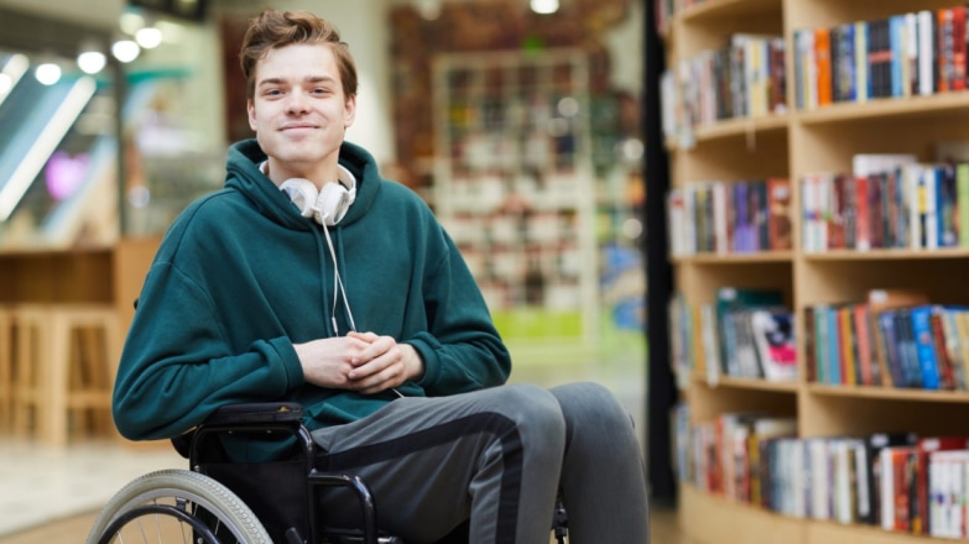 Young-man-in-wheelchair-in-the-school-library-5FBdWP