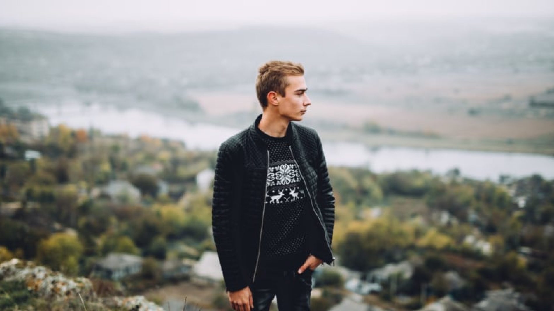Young-man-on-a-hill-looking-at-the-view-CjFlfZ