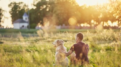 Young-man-with-dog-in-a-field-JA8xSF