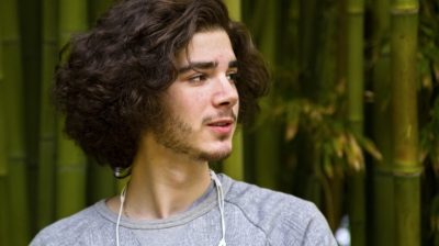 Young-man-with-long-hair-headphones-NaR9Nb