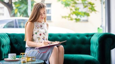 Young-perosn-on-a-couch-with-a-notebook-kqudNn