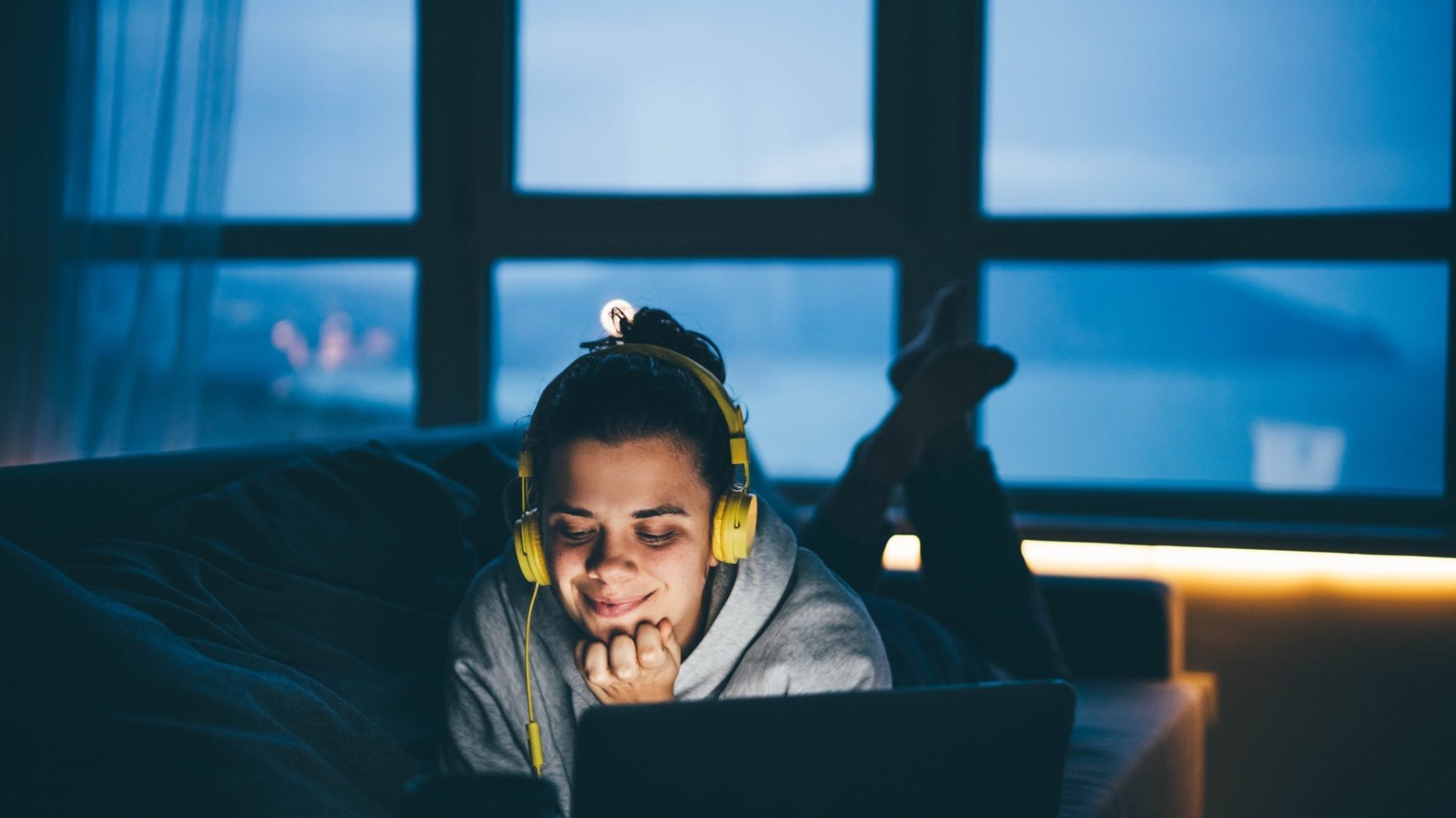 Young person listening to a podcast at night