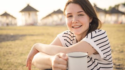 Young person sitting outside with tea