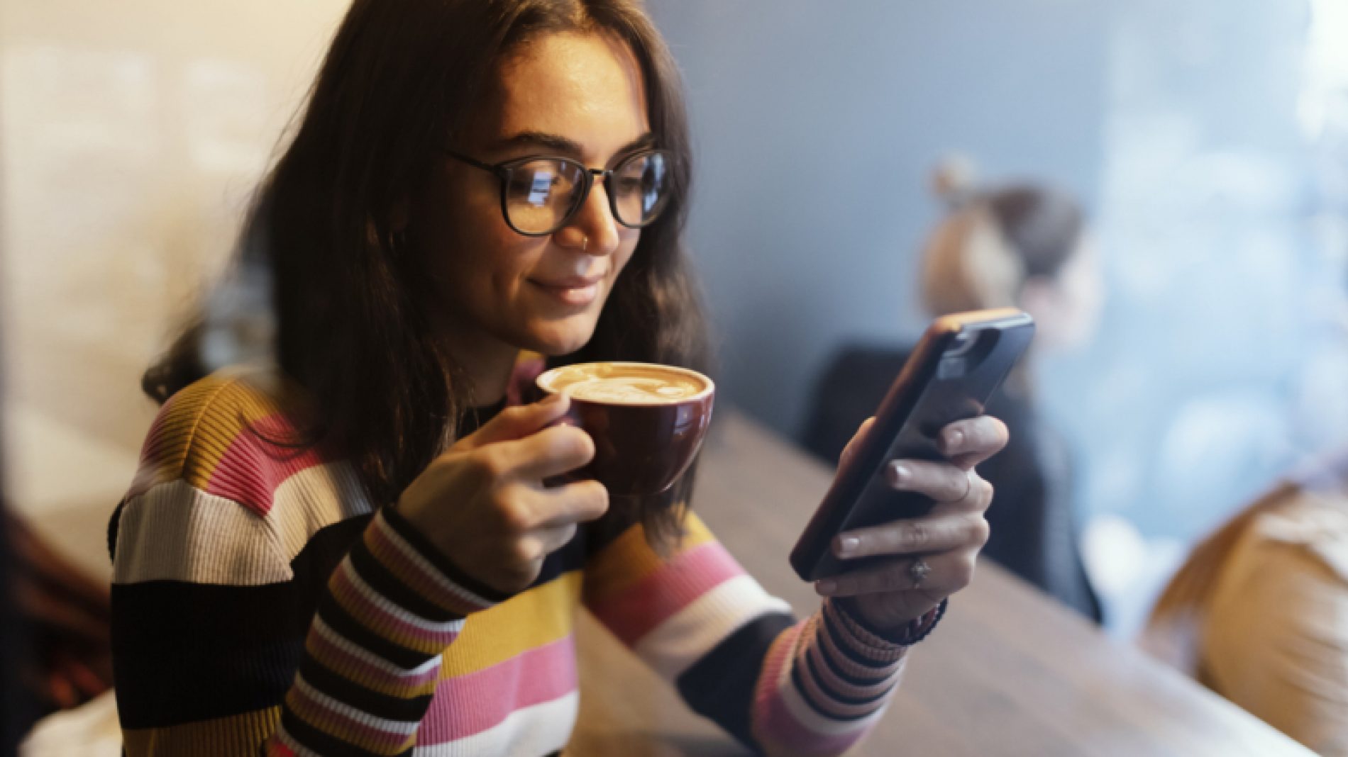 Young-woman-on-phone-with-coffee-gr8x1Y