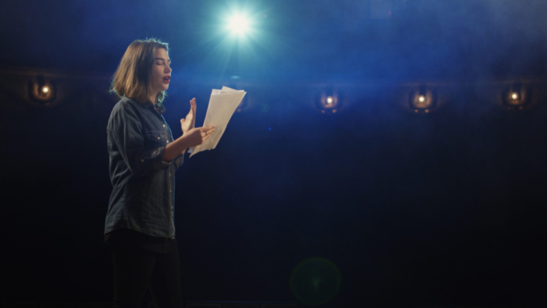 Young-woman-on-stage-with-script-DQzSeV