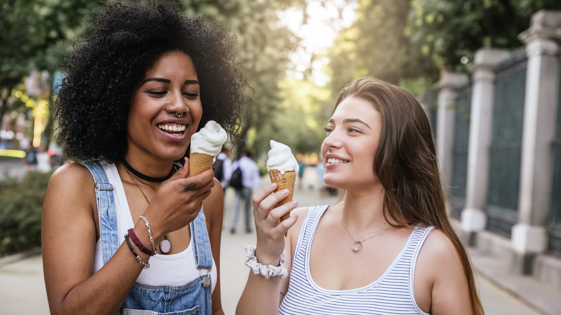 Beautiful women eating one ice cream in the street.