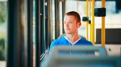 Young man listening to music on a bus