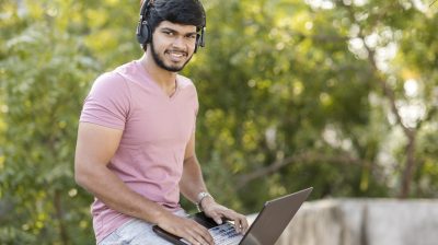 Young man on his laptop listening to music