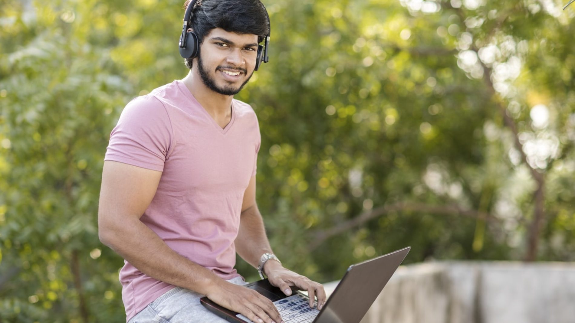 Young man on his laptop listening to music