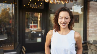 Women standing outside coffee shop smiling