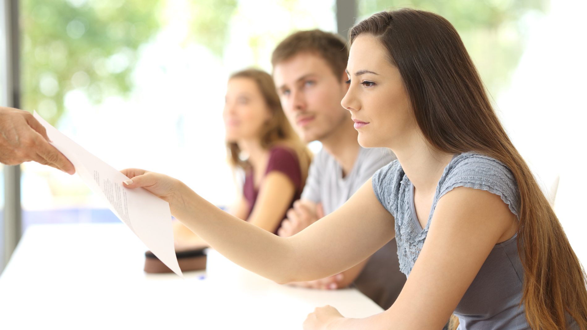 Student receiving an exam from the teacher