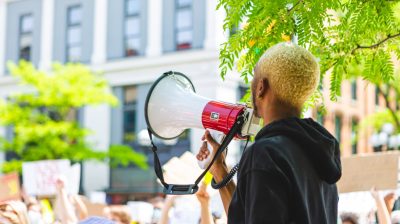 Photo of a person with a loudspeaker at a protest - burnout and activism