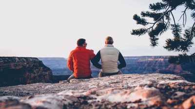 Two friends talking sitting on a mountain