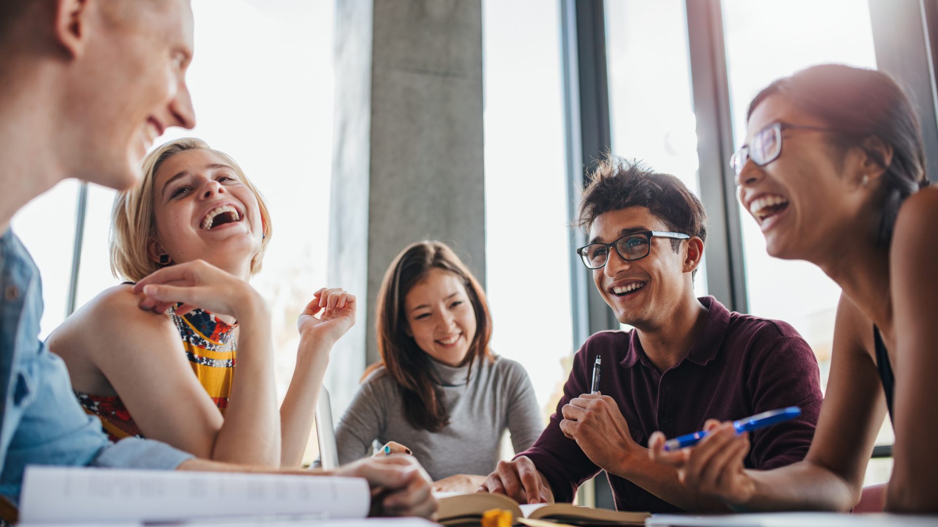 Group of happy young students in library