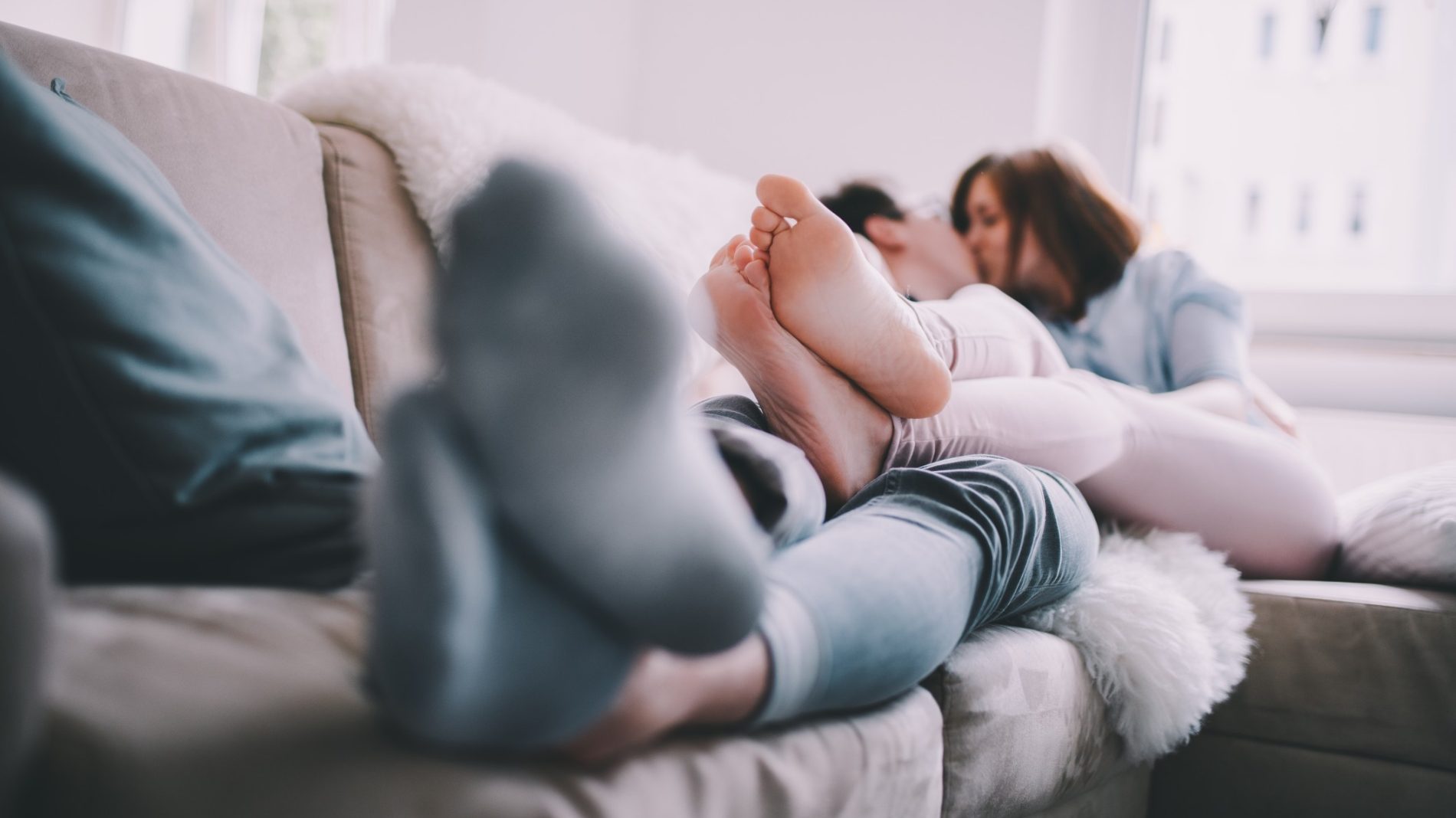 close-up-kissing-love-sofa-feet-home-couch-youth-laying-down-cuddling_t20_XQeoLR