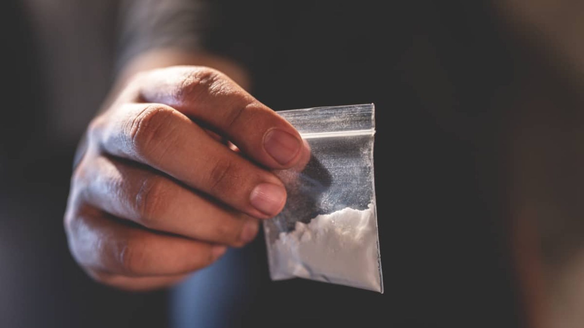 a bag of cocaine being held in someone's right hand