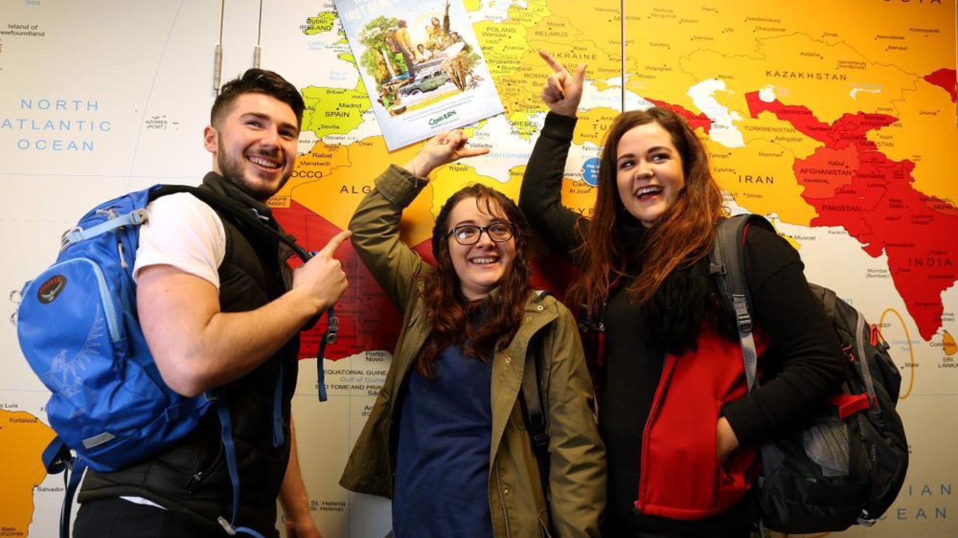group of young people in front of a map
