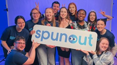 a number of spunout volunteers pose for a photo holding a large spunout sign