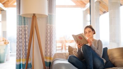 Woman reading on a couch at home