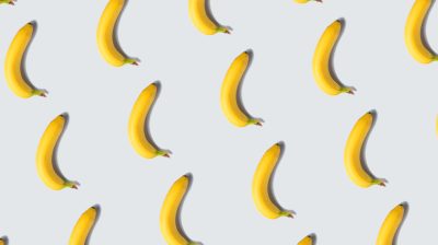 Single banana fruit pattern on light gray minimal background