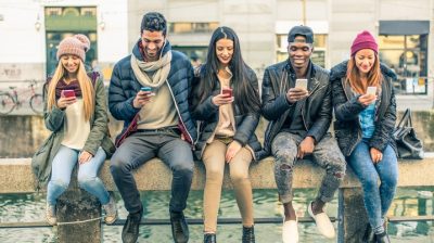 Group of people sitting looking at their smartphones