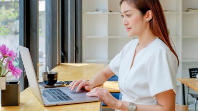 Photo of a person on their laptop with a mug of tea