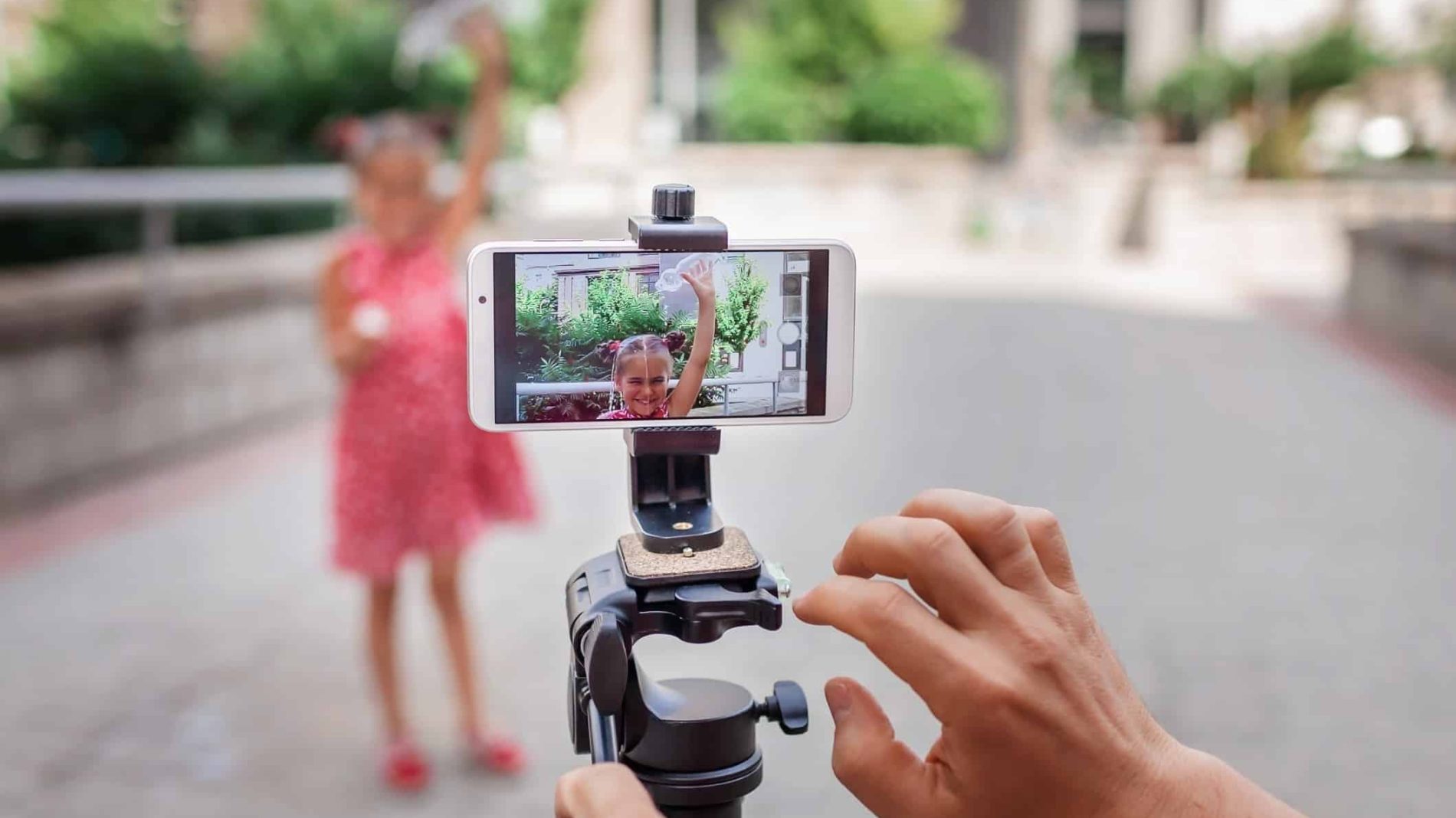 A person recording footage on their phone of a young girl