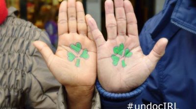 Two hands with shamrocks printed on them