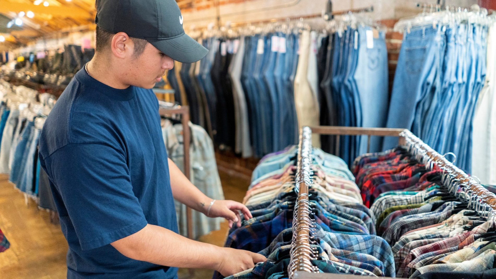 Photo of person browsing through a shirt rail in a clothes shop