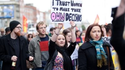 Young woman holds hand made poster about women decisions