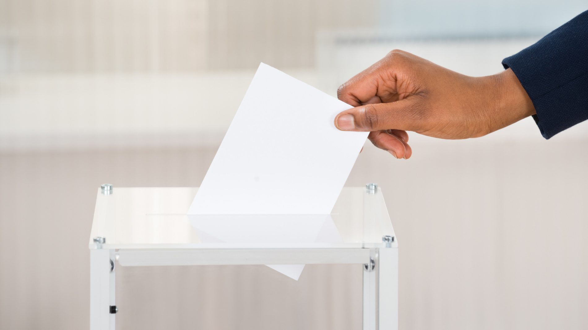 Person's Hand Putting Ballot In Box