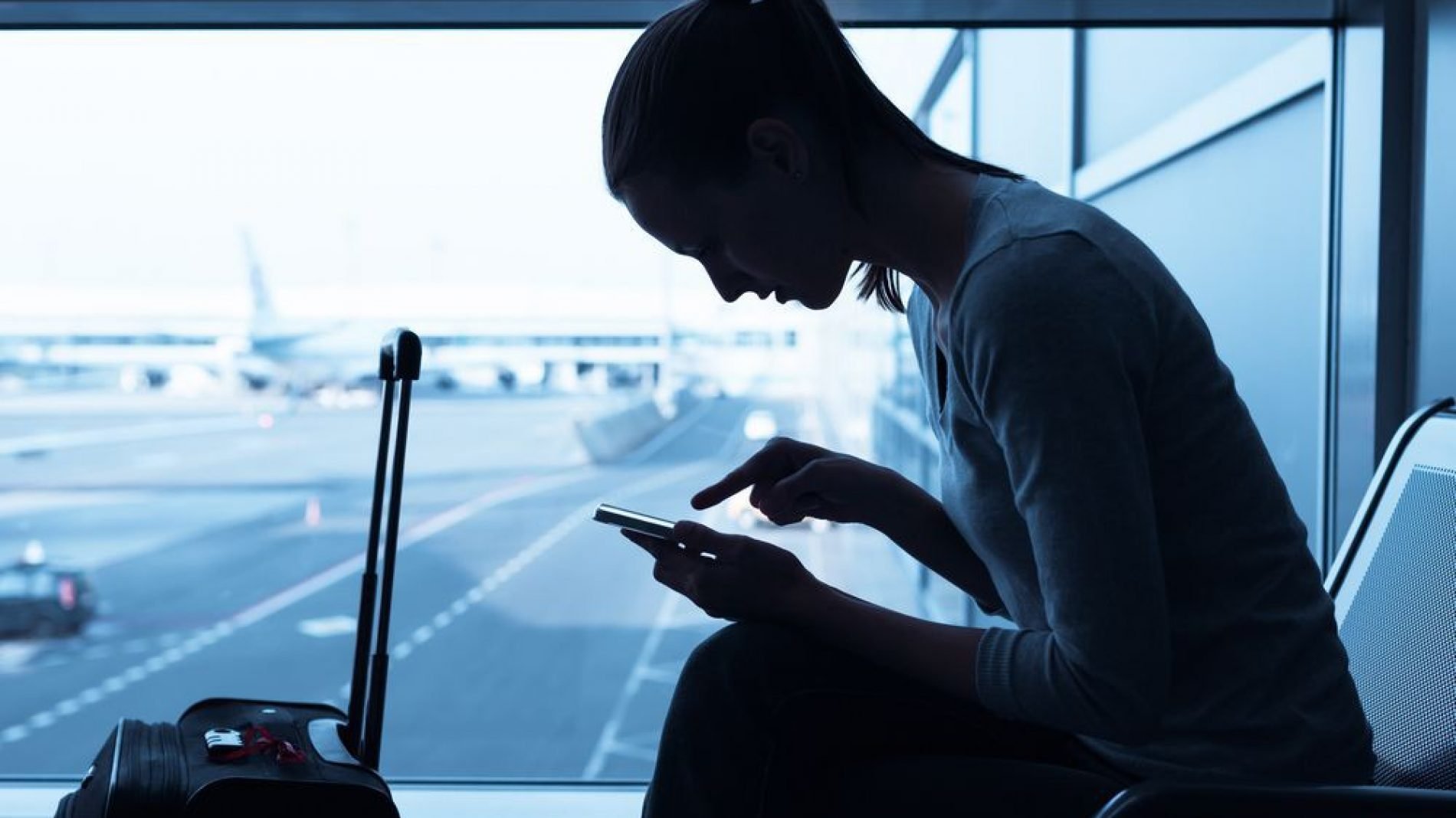Young woman using her phone in an airport