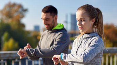 couple with fitness trackers training in city