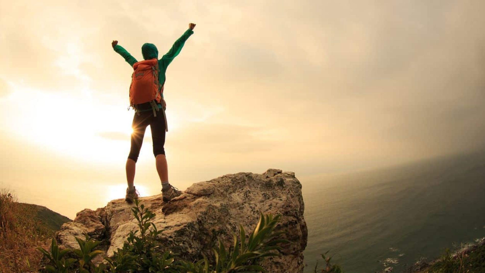 Person at the top of a mountain celebrating