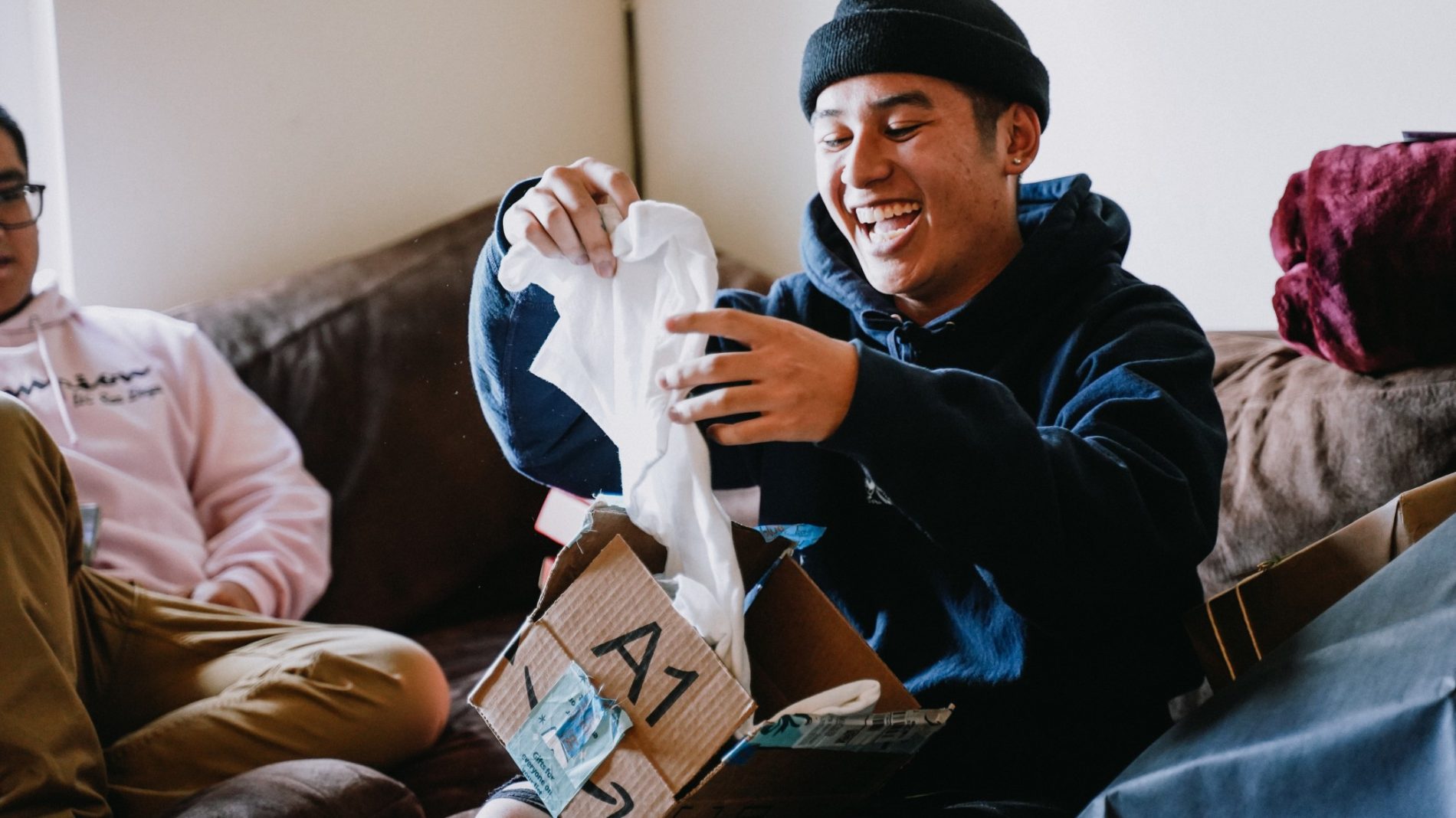 Photo of a person smiling while opening a present