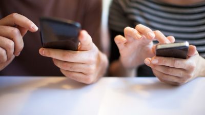 Girl and guy on cellphones using social media