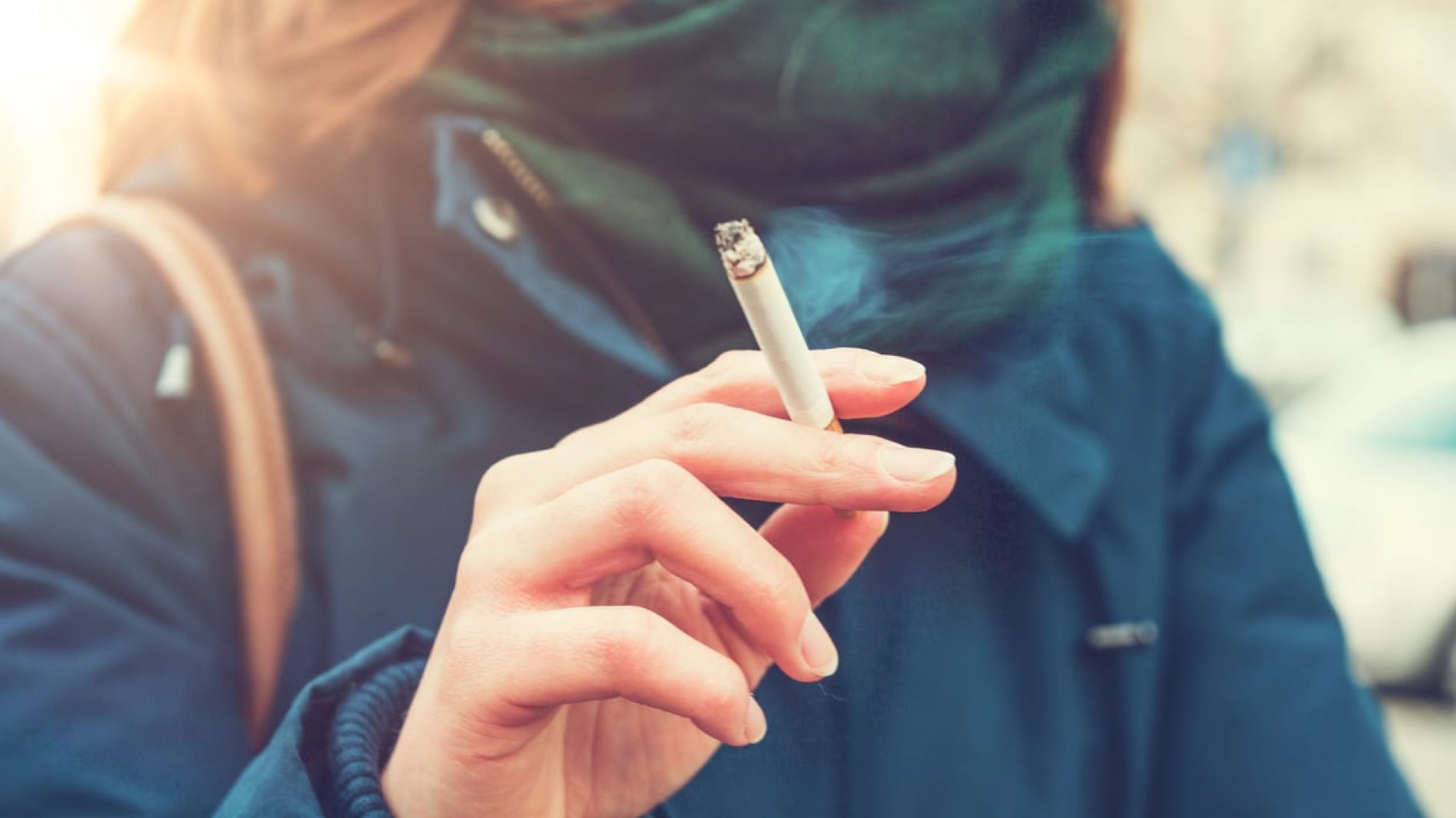A woman holding a lit cigarette