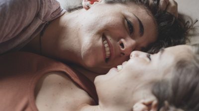 young-couple-smiling-in-bed