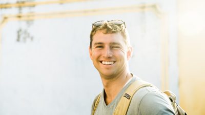 Young man smiling outside in the sun