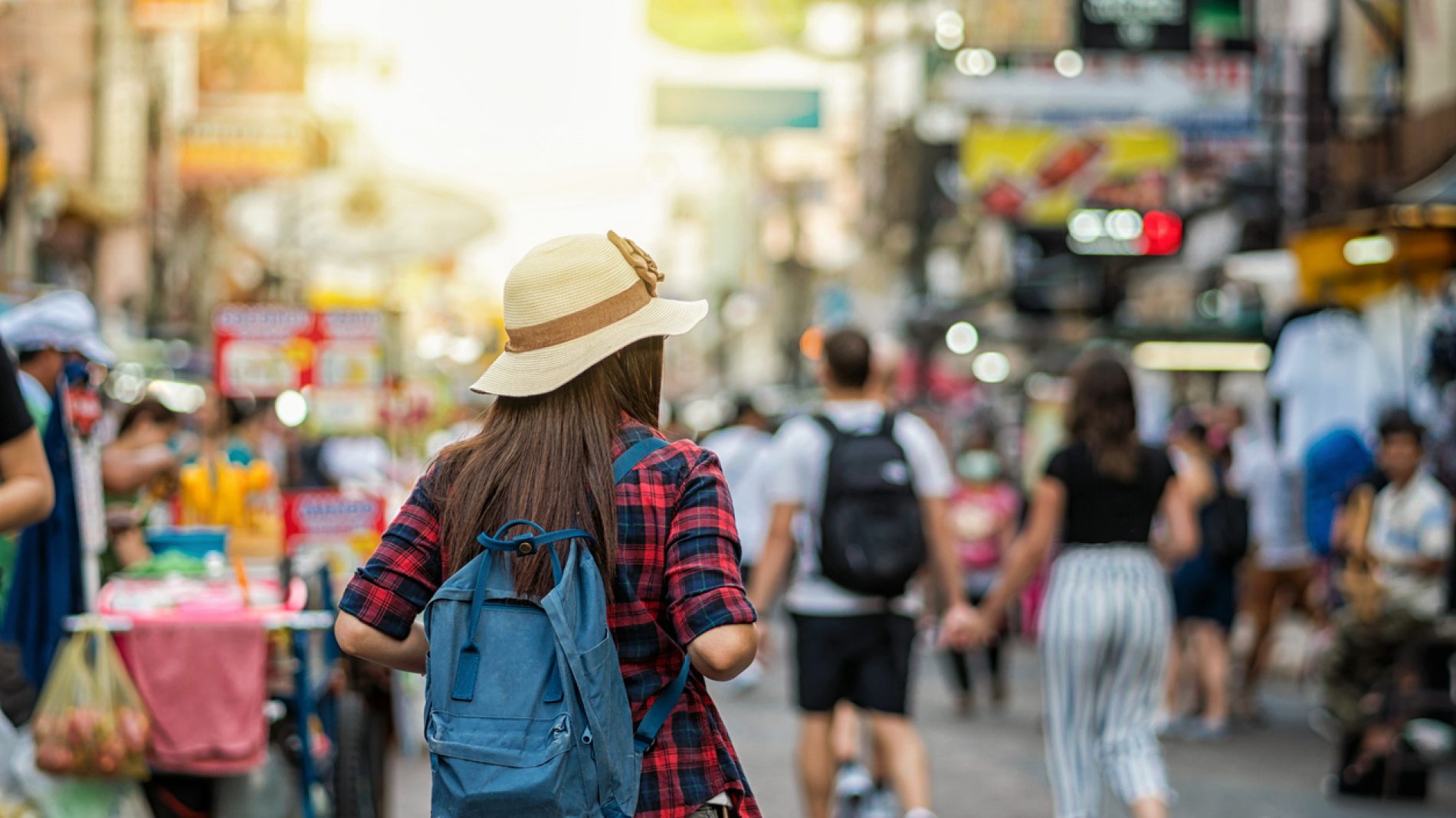 Back side of Young Asian traveling women walking and looking in Khaosan Road walking street in evening at Bangkok, Thailand, traveler and tourist concept